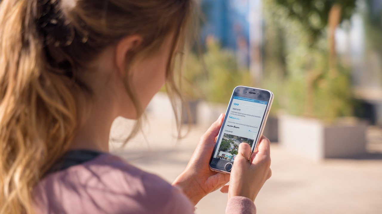 Dışarıda genç bir kişi, akıcı mobil kullanıcı deneyimiyle güvenli bir web sitesinde akıllı telefon kullanıyor.